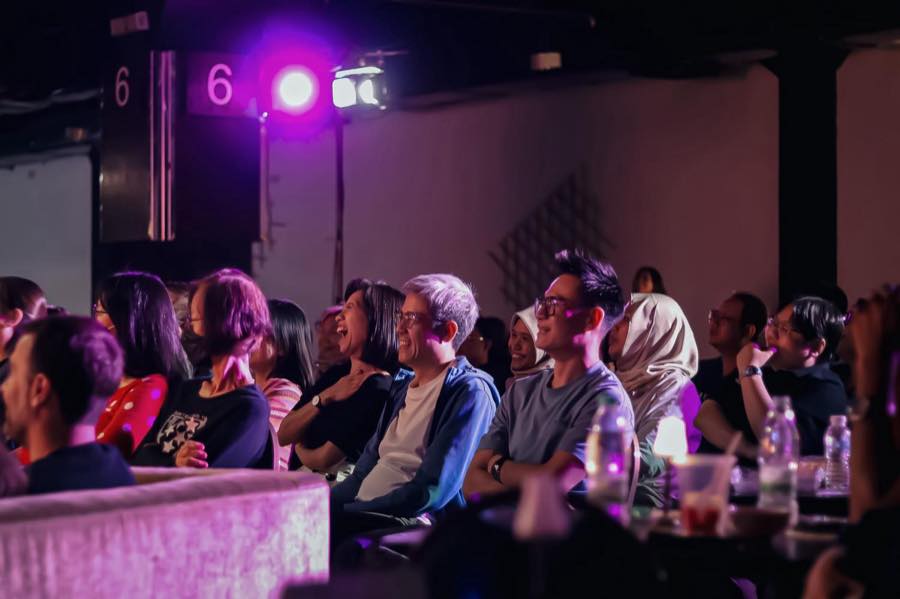 Audience members laughing during a talk in a small studio venue